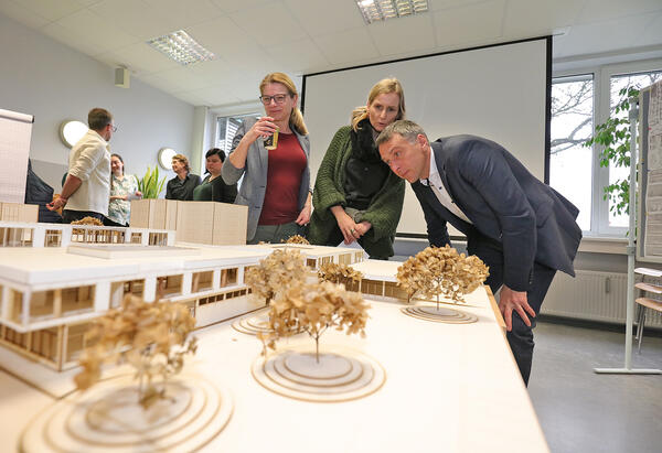 Landrat Dr. Stefan Kerth wirft gemeinsam mit Ricarda Rumpel, Fachbereichsleiterin &raquo;Interne Dienste&laquo;, und Heike Jungnickel, Sachbearbeiterin Hochbau, einen Blick auf die Projektarbeiten der Studierenden (v. r. n. l.)